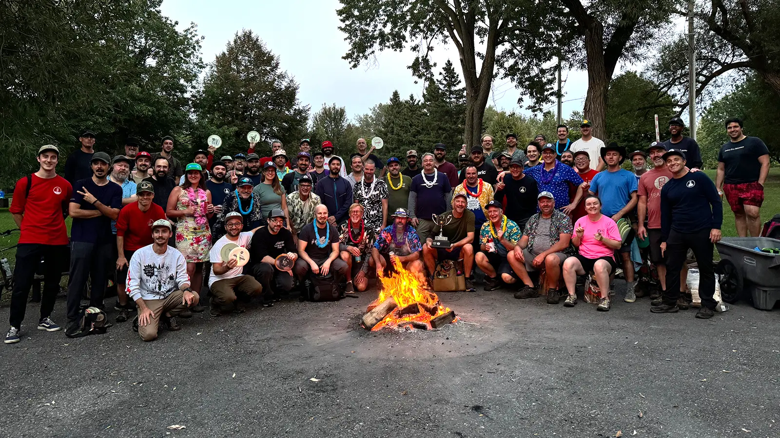 Glow Down Cup players gathered around a bonfire at dusk after the competition